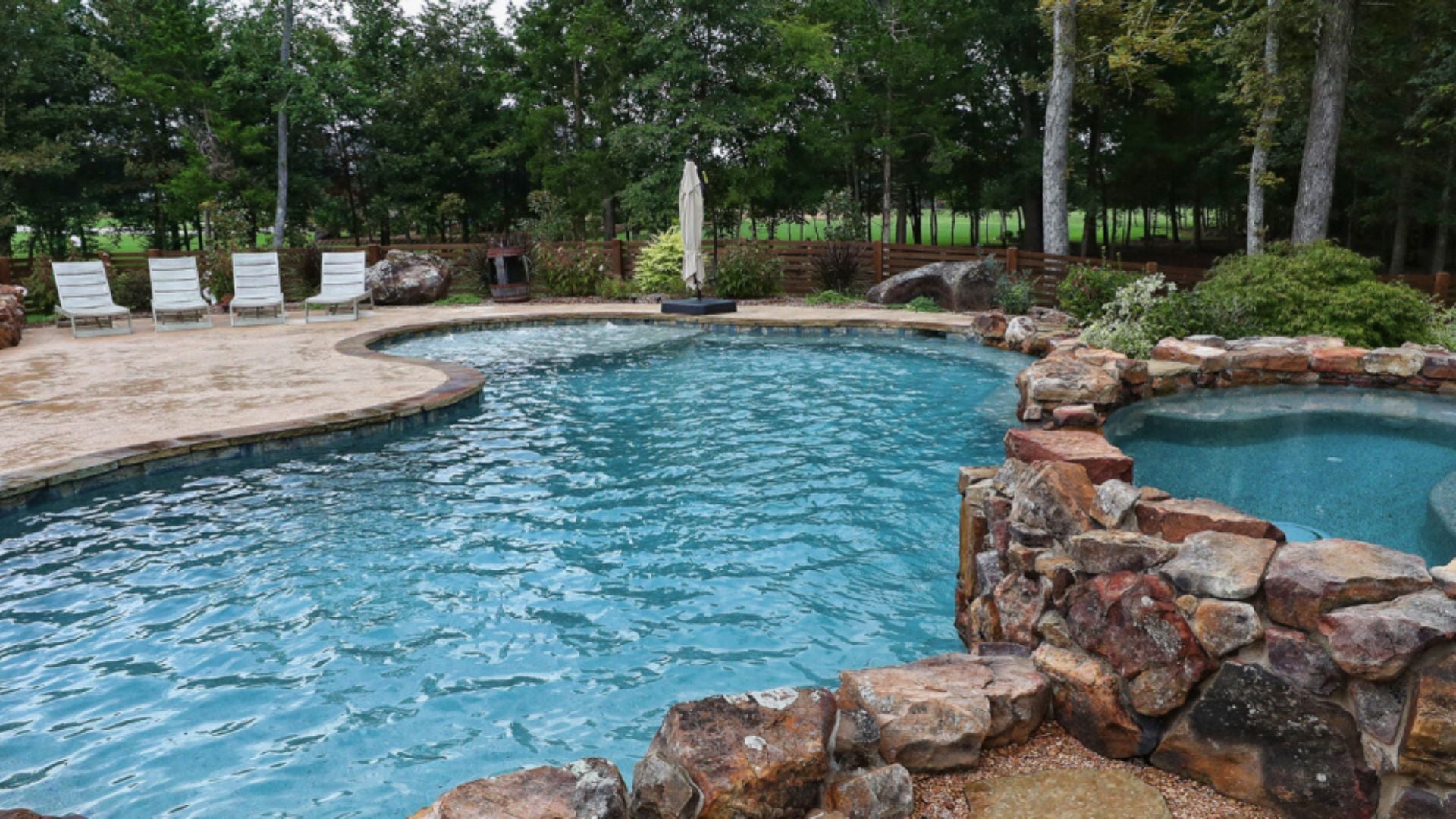 custom gunite pool shown with hot tub